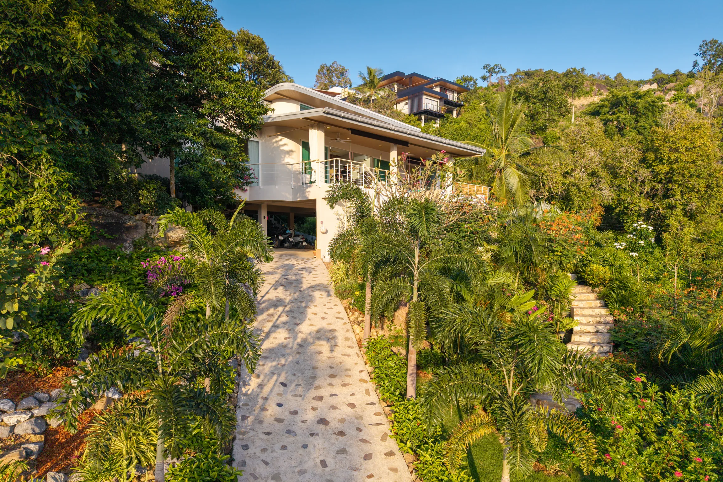 Private stone driveway and covered parking in the 1,600 m² landscaped garden