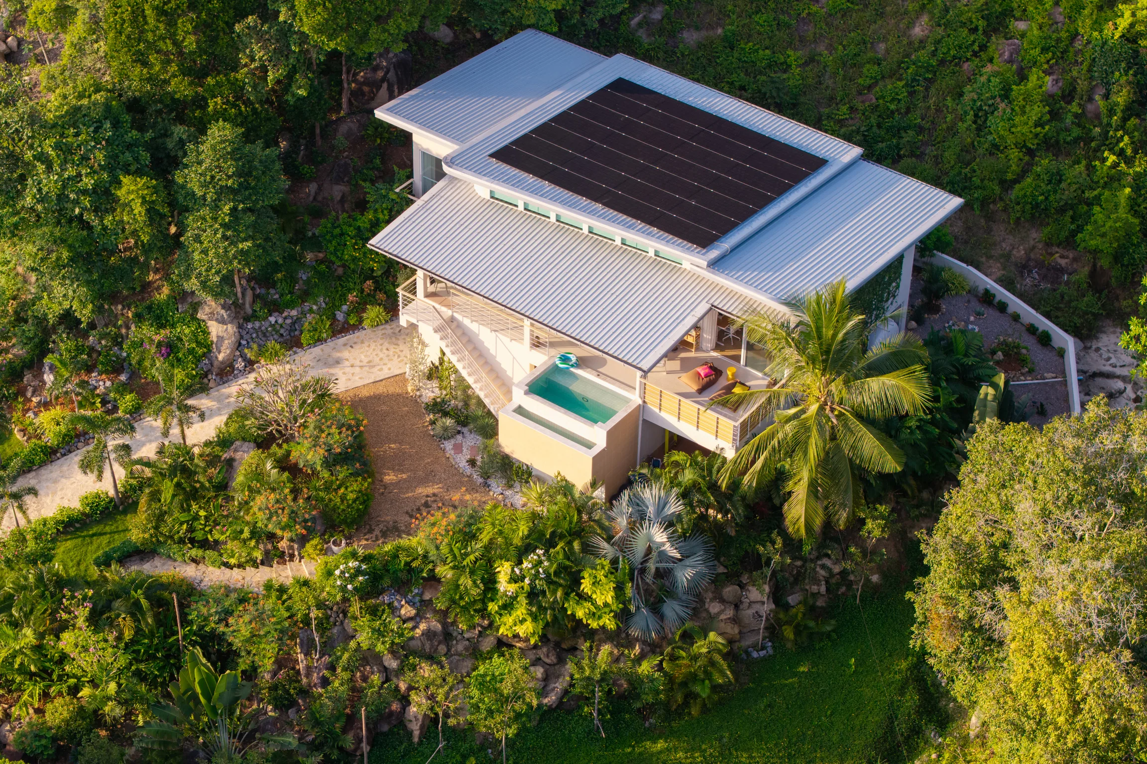 Aerial view showing the solar roof array, plunge pool, and tropical grounds